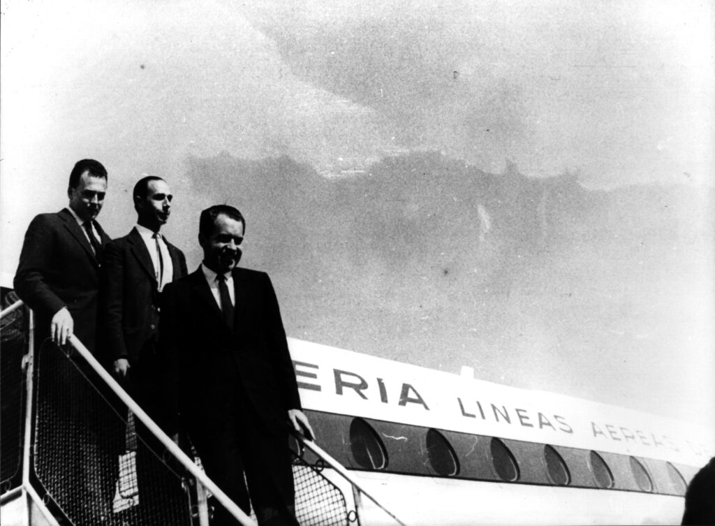 Richard Nixon e altre due persone mentre scendono da un aereo