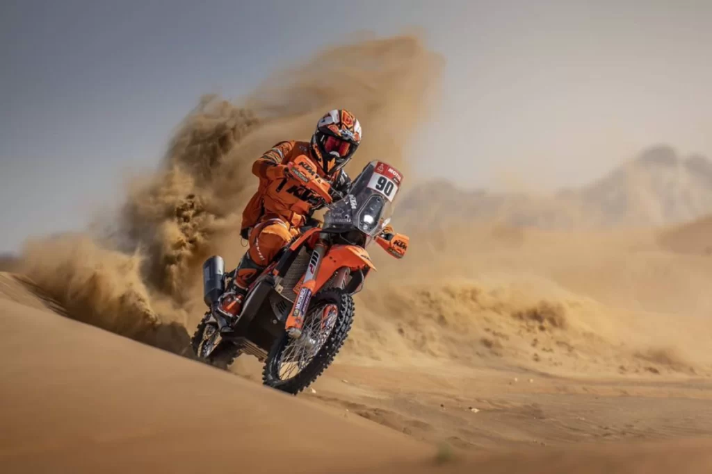 motociclista con una ktm sulle dune del deserto