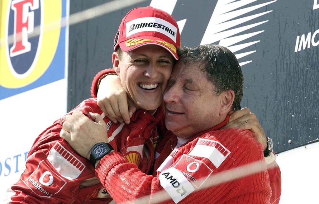 michael schumacher and jean todt celebrate the world championship won by hugging each other. on the wrist of a richard mille watch
