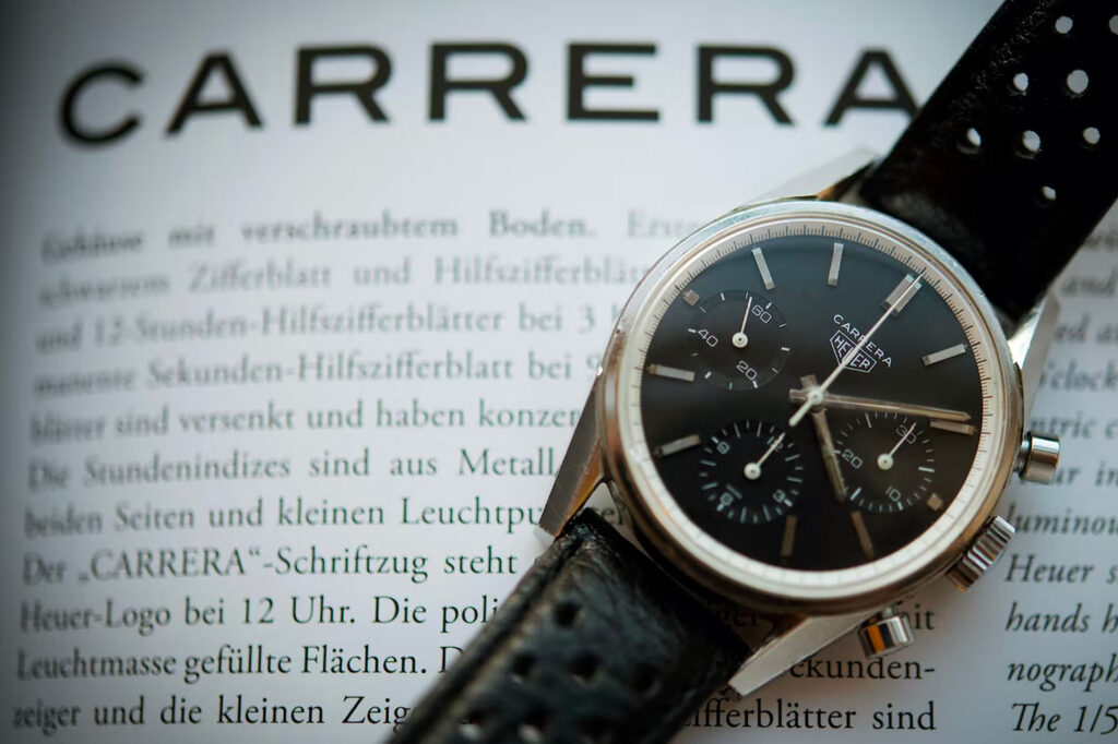 il primo orologio Heuer Carrera, con quadrante nero e rehaut bianca, scritta Carrera a ore 12 con logo sotto